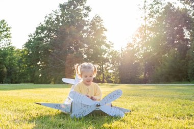 Uçan kız. Sarı karton kostümlü çocuk. Park aktivitesi, gün ışığı çocuğu.