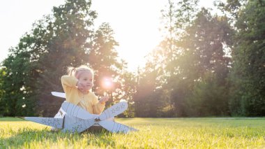 Uçağı olan çocuk. Kız karton pilot oyuncağı. Hayal gücü açık hava kostüm yazı