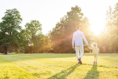 Baba çocuk. Baba yeni yürümeye başlayan kızıyla oynuyor.