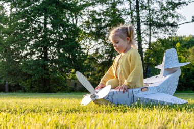 Küçük pilot. Uçak karton çocuk kostümü. Fantezi oyunu sarı çimen