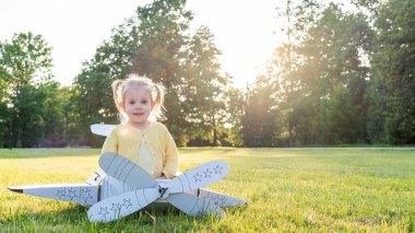 Küçük pilot. Uçak karton çocuk kostümü. Fantezi oyunu sarı çimen