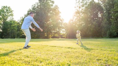 Baba çocuk. Baba yeni yürümeye başlayan kızıyla oynuyor.