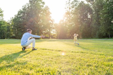 Baba kızı. Baba gün batımında küçük kızıyla koşuyor.