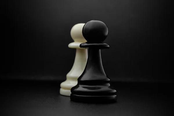 Шахматы. Черно-белые пешки на черном фоне. Пешки, пехотные шахматы . — стоковое фото