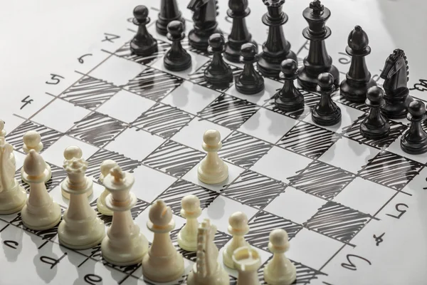 Les échecs. Les Blancs commencent. Plateau blanc avec des figures d'échecs dessus. Plan de bataille . — Photo