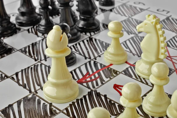 Chess. The white Bishop is under attack. White board with chess figures on it. Plan of battle. — Stock Photo, Image