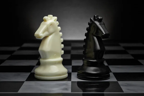 Les échecs. Chevaliers noirs et blancs sur le tableau. Ensemble de figures d'échecs . — Photo