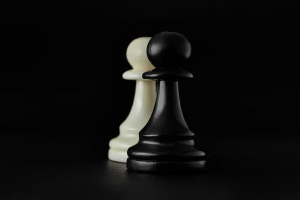 下象棋。在黑色背景上的黑色和白色棋子。步兵象棋棋子. — 图库照片