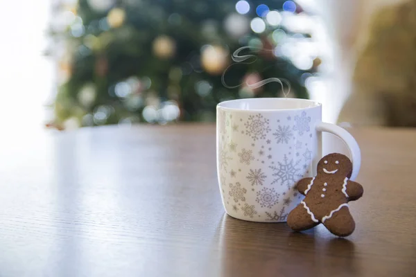 Winter background, white coffee cup with smoke and gingerbread man