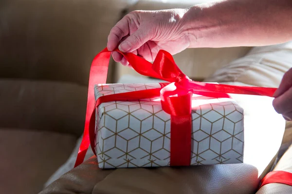Noel hediyesi paketi açılıyor, kırmızı kurdele.