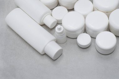 Model. Jel, losyon, krem için boş şişe ve kavanoz. Etiketsiz cilt ürünleri için beyaz plastik kaplar.
