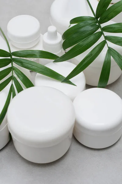 Model. Jel, losyon, krem için boş şişe ve kavanoz. Etiketsiz cilt ürünleri için beyaz plastik kaplar. Markasız güzellik ürünü paketi..
