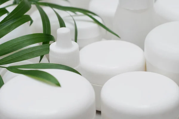 Model. Jel, losyon, krem için boş şişe ve kavanoz. Etiketsiz cilt ürünleri için beyaz plastik kaplar. Markasız güzellik ürünü paketi..