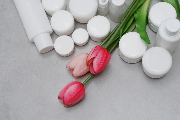 Model. Boş şişeler, jel, losyon, krem için kavanozlar. Etiketsiz beyaz plastik kaplar. Markasız güzellik ürünü paketi.