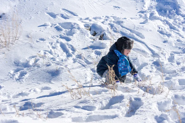 Karda oynarken küçük çocuk