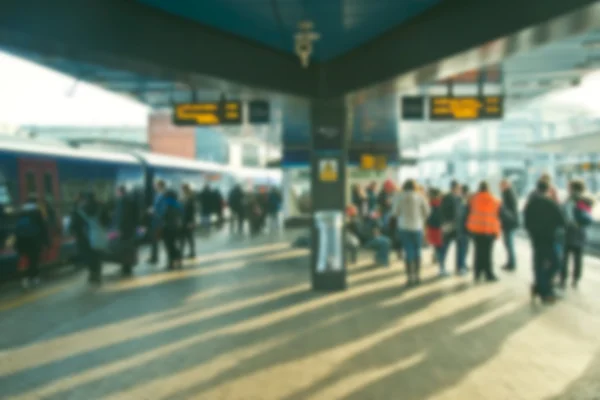 Personas en una estación de tren que viajan en tren — Foto de Stock