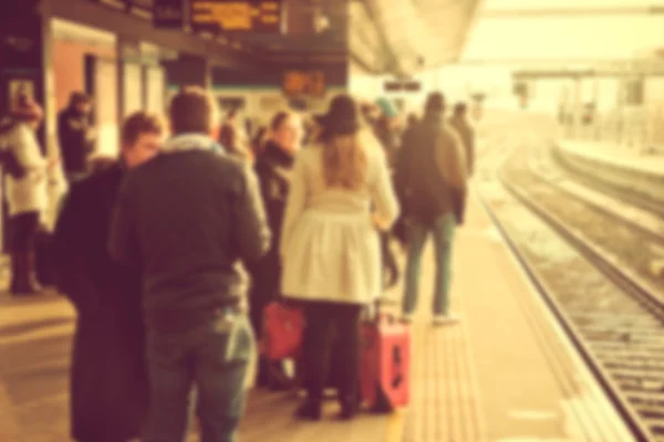 Personas en una estación de tren que viajan en tren — Foto de Stock