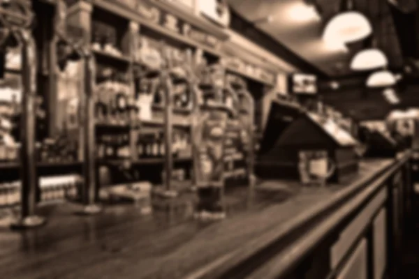 Klassieke bar teller met flessen in wazig achtergrond — Stockfoto