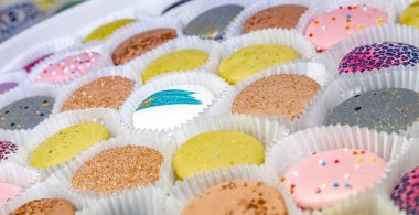 Bir pastanede ya da dükkanda tezgahın üzerinde farklı renkte makarna var. Renk arkaplanı