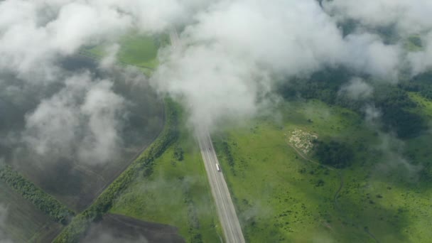 Автострада между полями Европы с воздуха. Низкая облачность. — стоковое видео