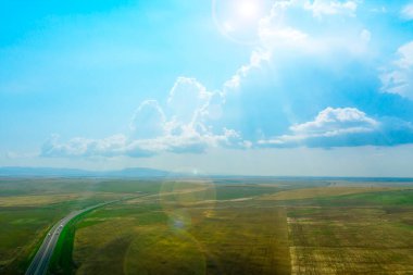 Kerch-Sivastopol otoyolunun hava görüntüsü, Kırım 'daki dağların arka planına karşı tarlalar arasında
