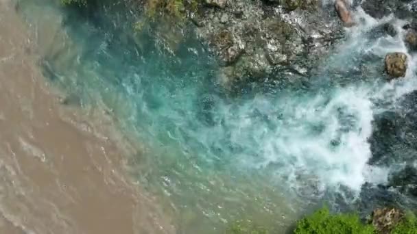 El agua limpia se encuentra con el agua sucia en un río glacial. Río sucio de montaña se mezcla con agua clara del lago — Vídeos de Stock