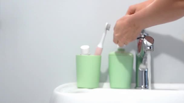 Una donna si lava accuratamente le mani con acqua tiepida e sapone, strofinando il polso in bagno a casa primo piano. protezione contro il coronavirus COVID19 spazio per testo — Video Stock