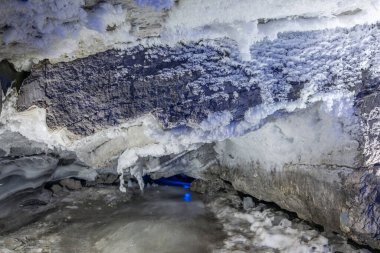 Entrance to ice cave with plenty of icicles. Slope of the mountain inside a fantastic cave. Kungur In The Urals, Russia