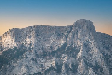Kayalık dağların görkemli manzarası güzel, berrak günbatımında uzanır. Kırım Dağları üzerinde pembe gün batımı. Konum Ai-Petri, Kırım.