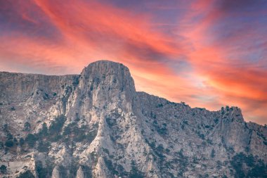 Kayalık dağların görkemli manzarası güzel pembe günbatımında uzanır. Kırım Dağları üzerinde pembe gün batımı. Konum Ai-Petri, Kırım.