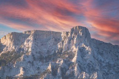 Kayalık dağların görkemli manzarası güzel pembe günbatımında uzanır. Kırım Dağları üzerinde pembe gün batımı. Konum Ai-Petri, Kırım.
