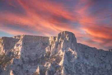 Kayalık dağların görkemli manzarası güzel pembe günbatımında uzanır. Kırım Dağları üzerinde pembe gün batımı. Konum Ai-Petri, Kırım.