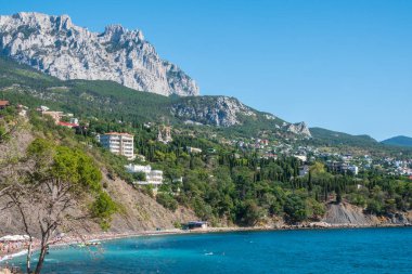 Kayalık plajları ve uçurumları olan deniz manzarası. Kırım 'da turizm. Bir deniz manzarasının yaz fotoğrafı. Kırım Dağları ve Alupka, Kırım yakınlarındaki deniz.