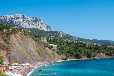Kayalık plajları ve uçurumları olan deniz manzarası. Kırım 'da turizm. Bir deniz manzarasının yaz fotoğrafı. Kırım Dağları ve Alupka, Kırım yakınlarındaki deniz.