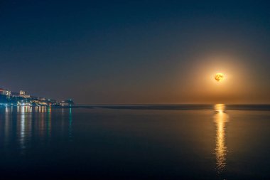 Süper dolunay ve deniz üzerinde ay ışığı. Dolunay, ay yüzeyinin detaylarıyla birlikte suda yansıyor..