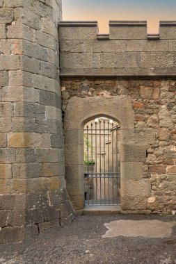 Eski kalede kapısı olan antik taş bir duvar. Ortaçağ şatosunun ahşap kapısı
