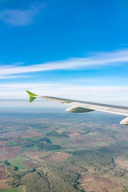 Moskova, Rusya 'ya iniş sırasında uçak kanadı, mavi gökyüzü ve kara manzarası. Uçak penceresi manzaralı. Dünya ve gökyüzü bir uçağın penceresinden görüldüğü gibi.