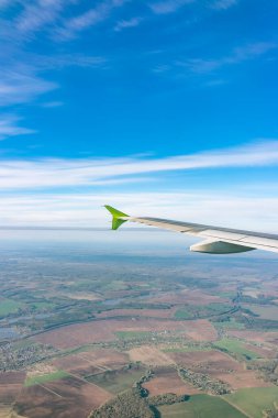 Moskova, Rusya 'ya iniş sırasında uçak kanadı, mavi gökyüzü ve kara manzarası. Uçak penceresi manzaralı. Dünya ve gökyüzü bir uçağın penceresinden görüldüğü gibi.