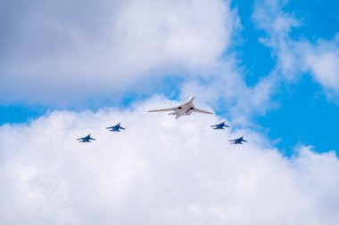 Moskova, Rusya - Mayıs 05, 2021: Tu-160 stratejik füze taşıyıcısı, 9 Mayıs geçit töreninin hazırlık ve provası sırasında dört Su-35S savaş jeti ile Kızıl Meydan üzerinde uçuyor..