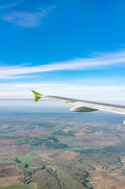 Moskova, Rusya 'ya iniş sırasında uçak kanadı, mavi gökyüzü ve kara manzarası. Uçak penceresi manzaralı. Dünya ve gökyüzü bir uçağın penceresinden görüldüğü gibi.