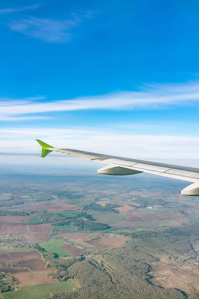 Moskova, Rusya 'ya iniş sırasında uçak kanadı, mavi gökyüzü ve kara manzarası. Uçak penceresi manzaralı. Dünya ve gökyüzü bir uçağın penceresinden görüldüğü gibi.