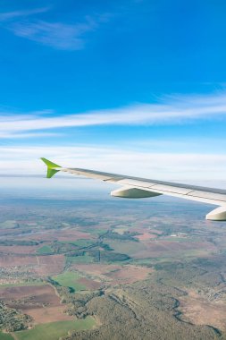Moskova, Rusya 'ya iniş sırasında uçak kanadı, mavi gökyüzü ve kara manzarası. Uçak penceresi manzaralı. Dünya ve gökyüzü bir uçağın penceresinden görüldüğü gibi.