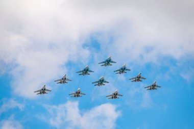 Moskova, Rusya - 5 Mayıs 2021: Savaşçılar Su-35S ve Su-30SM, taktik kanat grubuyla Kızıl Meydan üzerinde mavi gökyüzünde Su-34 bombardıman uçaklarıyla birlikte. Moskova 'daki Zafer Günü geçit töreninin havacılık kısmı. Su-34 bombardıman uçağı gurubu Fullback, Su-35