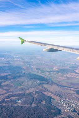 Güzel mavi bir güneş doğarken uçak penceresinden ve açık havada uçağın kanadını seyret. Dünya ve gökyüzü bir uçağın penceresinden görüldüğü gibi.