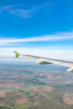 Moskova, Rusya 'ya iniş sırasında uçak kanadı, mavi gökyüzü ve kara manzarası. Uçak penceresi manzaralı. Dünya ve gökyüzü bir uçağın penceresinden görüldüğü gibi.