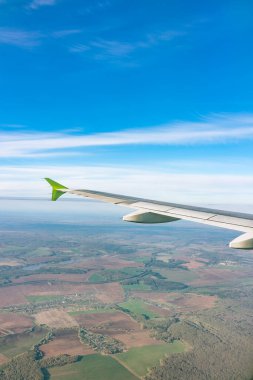 Moskova, Rusya 'ya iniş sırasında uçak kanadı, mavi gökyüzü ve kara manzarası. Uçak penceresi manzaralı. Dünya ve gökyüzü bir uçağın penceresinden görüldüğü gibi.
