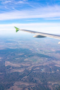 Güzel mavi bir güneş doğarken uçak penceresinden ve açık havada uçağın kanadını seyret. Dünya ve gökyüzü bir uçağın penceresinden görüldüğü gibi.