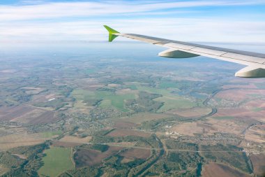 Güzel mavi bir güneş doğarken uçak penceresinden ve açık havada uçağın kanadını seyret. Dünya ve gökyüzü bir uçağın penceresinden görüldüğü gibi.