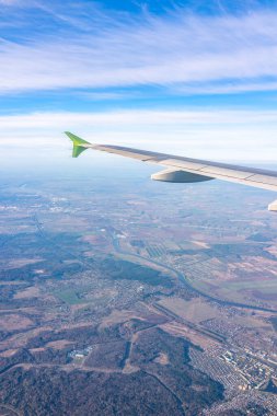 Güzel mavi bir güneş doğarken uçak penceresinden ve açık havada uçağın kanadını seyret. Dünya ve gökyüzü bir uçağın penceresinden görüldüğü gibi.