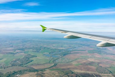 Güzel mavi bir güneş doğarken uçak penceresinden ve açık havada uçağın kanadını seyret. Dünya ve gökyüzü bir uçağın penceresinden görüldüğü gibi.